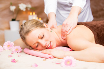 Fototapeta na wymiar Young beautiful woman enjoying massage at spa studio