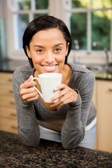 Smiling brunette holding white cup