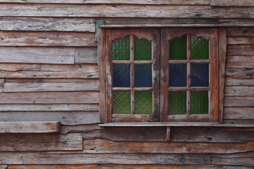 Fototapeta na wymiar Old wooden house with colorful window 