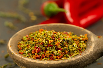 Red hot chili pepper on vintage black table. Colorful dried natural herbs and spices.