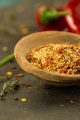 Red hot chili pepper on vintage black table. Colorful dried natural herbs and spices.