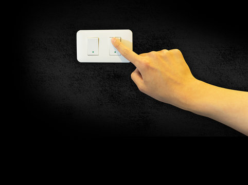 Man hand turn on a light switch on cement background