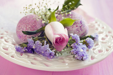 Pink Easter eggs and flowers on a plate