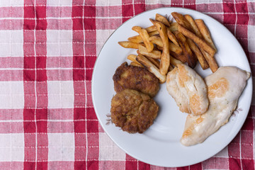 Served chichen meat beef meatballs and french fries