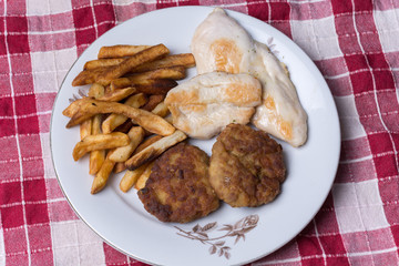 Served chichen meat beef meatballs and french fries