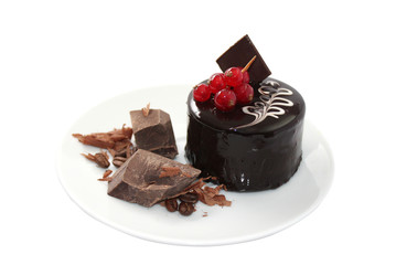 Cake with coffee beans and pieces of dark chocolate on white pla