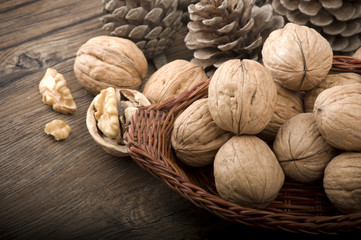 Walnut kernels and whole walnuts on rustic old wooden table