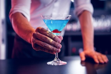 Bartender serving a blue martini