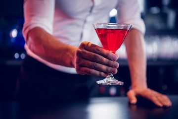 Bartender serving a red martini