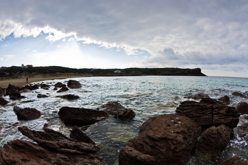 Sea rocks and waves at beach in San Pietro island, Sardinia, Italy