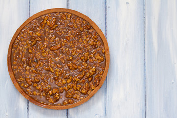 nuts tart with caramel on wooden background