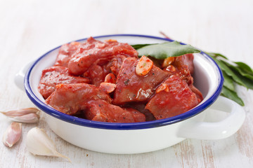 meat in sauce with garlic and bay leaf on dish