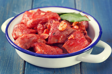 meat in marinate with garlic and bay leaf on dish