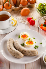 Easter breakfast - eggs, boiled white sausages and vegetables