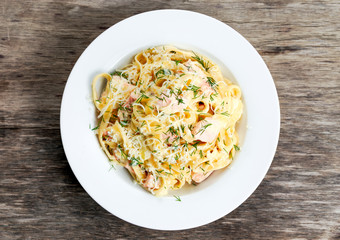 tasty pasta with salmon, dill, cheese on plate.