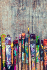 Row of artist paint brushes closeup on old rustic wooden backgro
