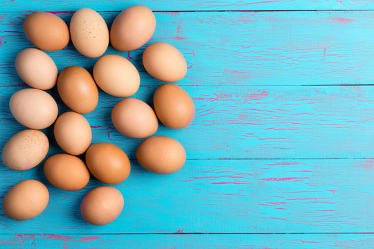 Fresh healthy brown eggs on a colorful blue table