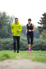 Naklejka premium Young couple running in the park