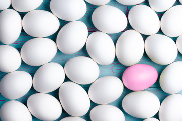 Large number of white Easter eggs and one pink one