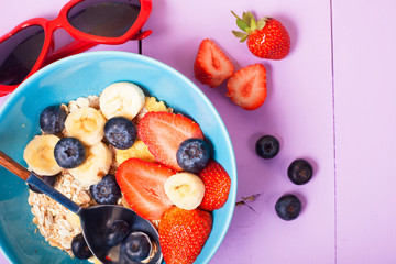 Healthy breakfast on pink wooden table. top view. heart shape sunglasses
