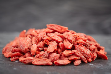 Pile of goji berries on a black stone plate