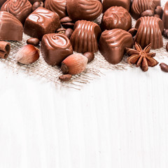 Delicious chocolate candies on wooden background
