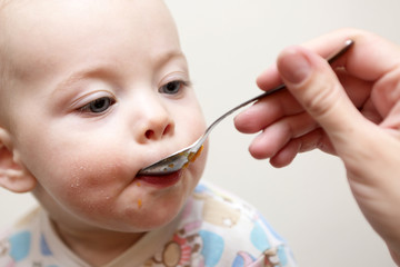 Serious baby has dinner