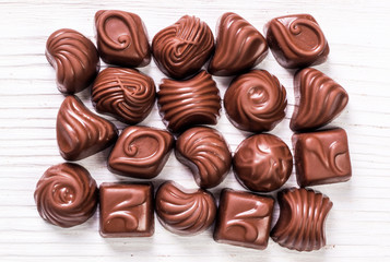 Delicious chocolate candies on wooden background