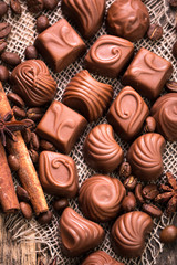 Delicious chocolate candies on wooden background