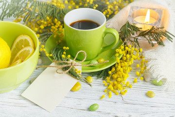 mimosa, lemon and coffee on light wooden background