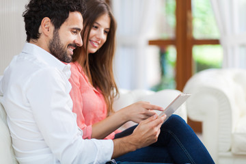 Portrait of an happy couple using a tablet