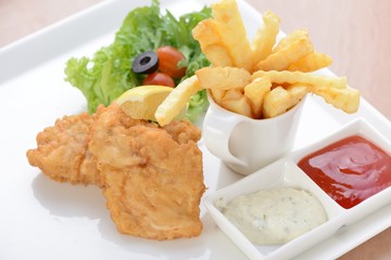 Fish dish - fried fish fillet with vegetables on white tray