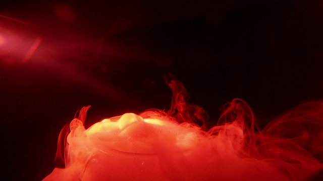 Infernal Hells Mist Swirling at Outlet of Glass Vessel on a Background of Total Darkness Close up