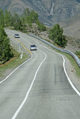 Fototapeta premium SIBERIA, RUSSIA - JUNE 10, 2012: Cars on the Russian route M52 (R256), also known as Chuya Highway or Chuysky Trakt from Novosibirsk to Russia's border with Mongolia