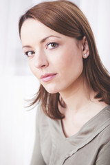 Fototapeta premium Attractive brown haired casual dressed woman smiling into camera