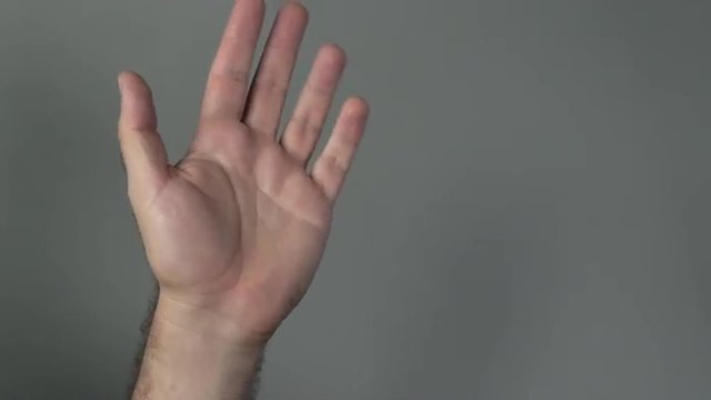 Man hand wave hello on a grey background. Concepts and ideas with copy spaceThis video is about W