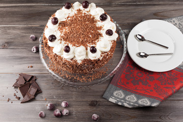 Black forest cake decorated with whipped cream and cherries. 