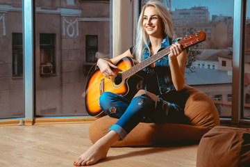 lovely girl smiling and having fun playing the guitar