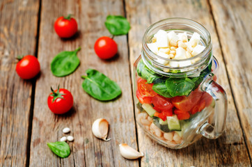 White beans cucumber tomato red pepper feta spinach salad in a j