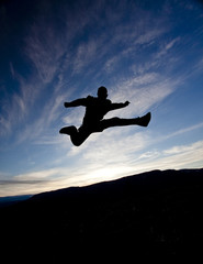 silhouette of a person jumping against the sunset sky