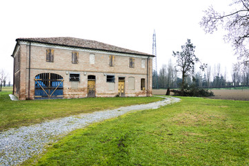 Fototapeta na wymiar Abandoned old italian farmhouse with felled tree