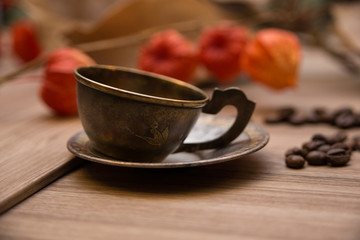 Old retro vintage copper coffee cup on wooden table