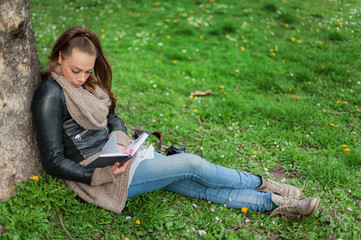 Young woman reading book / Closeup of a beautiful young woman reading book at park