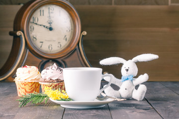 Closeup cup of tea and cupcakes on wooden table