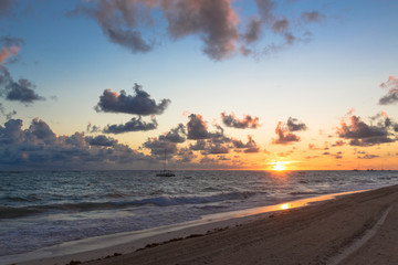 Fluffy dark clouds floating over turbulent ocean waters on sandy beach shore