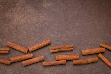 Cinnamon sticks on light brown background
