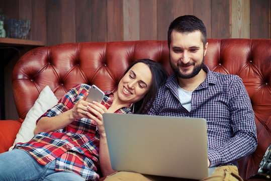 couple using smartphone and laptop