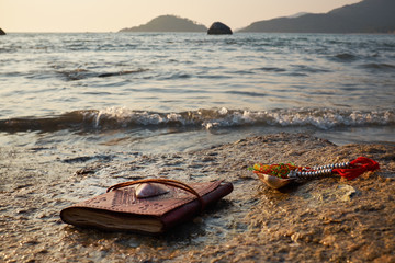 tropical sunset rocky beach with old vintage notebook