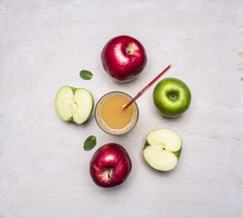 freshly squeezed apple juice from different varieties of apples on wooden rustic background top view close up