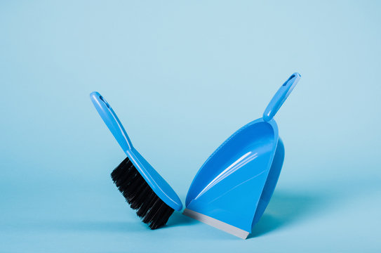 Cleaning concept - dustpan and sweeper on blue gradient backdrop